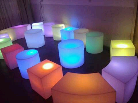 Living lounge luminoso con cubos LED en rooftop nocturno